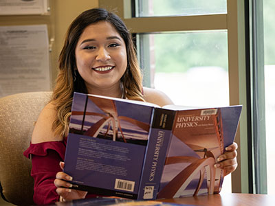 a woman holding a large textbook