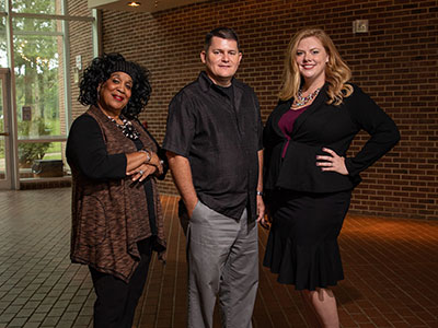 three faculty members standing side by side